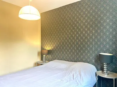 a bedroom with a bed and two tables with lamps at Superbe T4 proche Aix centre ville avec clim et parking in Aix-en-Provence