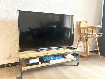 a large flat screen tv on a wooden tv stand at Superbe T4 proche Aix centre ville avec clim et parking in Aix-en-Provence