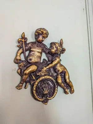 a gold plaque of a child and a dog with a cross at Plein centre d'Aix, bel appartement T2 rénové in Aix-en-Provence