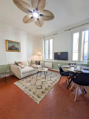 a living room with a couch and a ceiling fan at Plein centre d'Aix, bel appartement T2 rénové in Aix-en-Provence