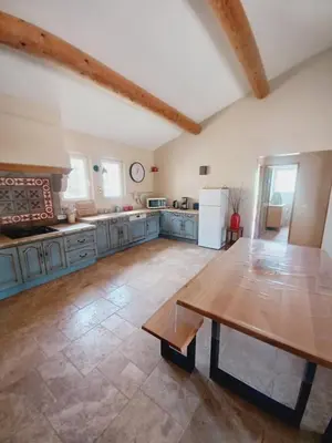a large kitchen with a wooden table in the middle at la Sainte Victoire in Jouques