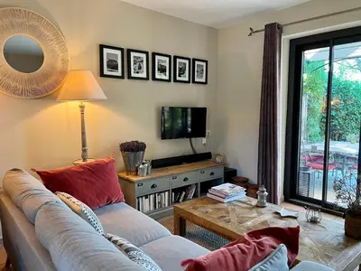 a living room with a couch and a tv at Jolie maison avec piscine à Gordes in Gordes