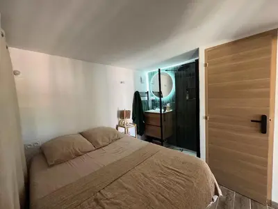 a bedroom with a bed and a door to a bathroom at COZY LOFT - Maisonnette esprit loft in Saint-Cannat