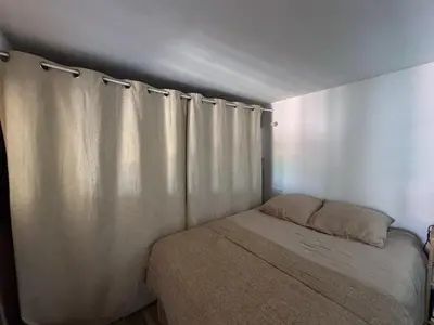 a small bedroom with a bed and a curtain at COZY LOFT - Maisonnette esprit loft in Saint-Cannat