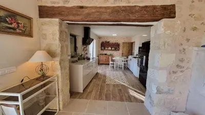 a kitchen and living room with a stone wall at La Fabrique in Gargas