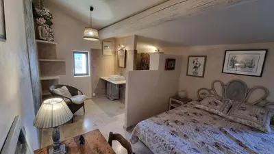 a bedroom with a bed and a desk and a sink at La Fabrique in Gargas