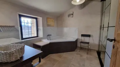a bathroom with a tub and a sink at La Fabrique in Gargas