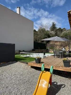 a backyard with a yellow slide and a wooden deck at Villa situé à Sainte-Tulle in Sainte-Tulle