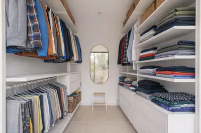 a walk in closet with white shelves and a mirror at Elynéa - Vue panoramique - Haut standing - Piscine in Rognes