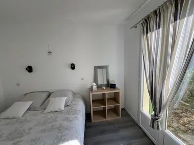 a bedroom with a bed and a mirror and a window at Appartement Domaine du Golf de Pont Royal in Mallemort