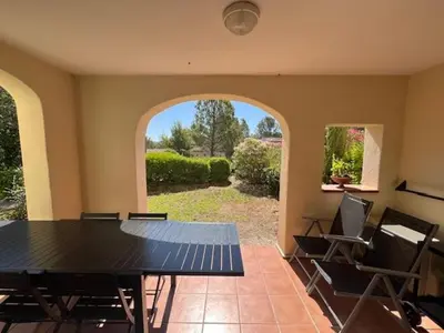 a dining room with a table and chairs and an archway at Appartement Domaine du Golf de Pont Royal in Mallemort