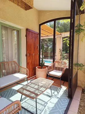a patio with two chairs and a table on a porch at Maison Maïtri in Lauris