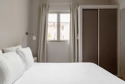 a bedroom with a white bed and a window at Appartement centre ville, Air Conditionné, 2 suites, parking sur demande in Aix-en-Provence