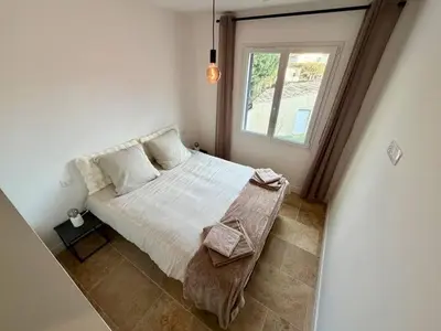a bedroom with a large bed with a window at Le Nid in Châteaurenard