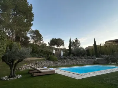 a swimming pool in a yard with two lounge chairs and a tree at Bastide Lavandin - Stunning Provencal Escape in Ventabren