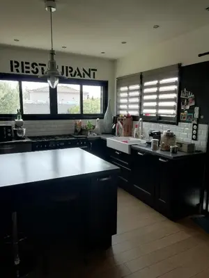a kitchen with black cabinets and a white counter top at Maison individuelle in Morières-lès-Avignon