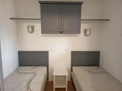 two beds in a room with a cabinet and a table at Golf de pont royal in Mallemort