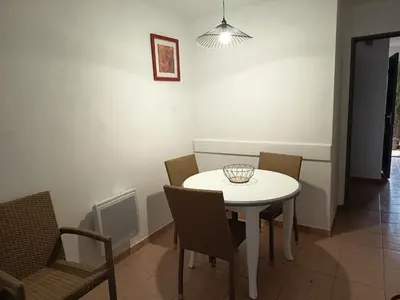 a dining room with a white table and chairs at Golf de pont royal in Mallemort