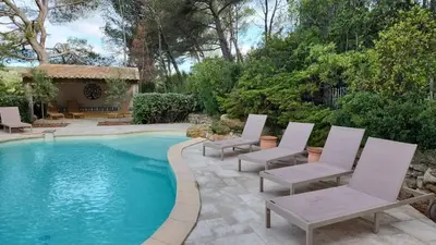 a swimming pool with white chairs next to a yard at Villa confortable avec jardin à Rognes – 200 m² in Rognes