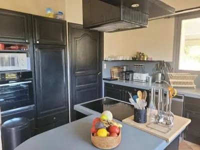 a kitchen with a bowl of fruit on a counter at Villa confortable avec jardin à Rognes – 200 m² in Rognes