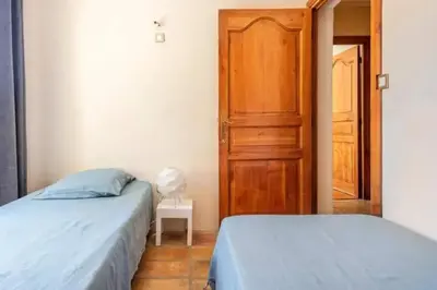 a bedroom with two beds and an open door at Villa confortable avec jardin à Rognes – 200 m² in Rognes