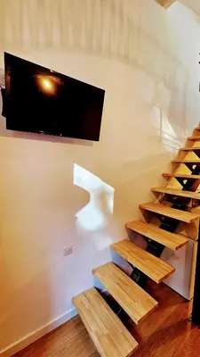 a wine cellar with wooden stairs and a tv on the wall at Duplex Aix Sunset Coeur centre historique in Aix-en-Provence