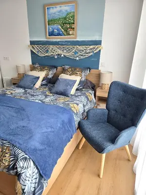 a bedroom with a bed and a blue chair at Studio Bleu Aix-en-Provence terrasse, piscine, parking in Aix-en-Provence