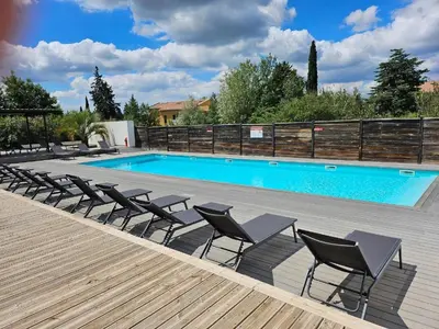 a swimming pool with lounge chairs next to a swimming pool at Studio Bleu Aix-en-Provence terrasse, piscine, parking in Aix-en-Provence