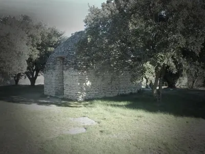 an old brick building in a field with trees at Bastidon du Chene in Gordes