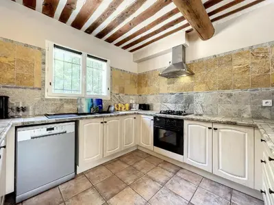 a kitchen with white cabinets and a stove at Maison LEA in Bédoin