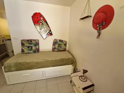 a small bedroom with a bed and a surfboard on the wall at Studio DOUILLET in Aix-en-Provence