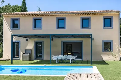a villa with a swimming pool in front of a house at Maison en Provence avec piscine in Éguilles