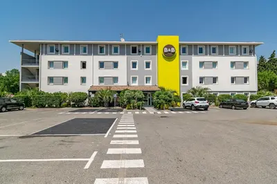 a parking lot in front of a large building at B&B HOTEL Salon de Provence in Salon-de-Provence