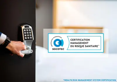 a person holding a remote control in front of a sign at B&B HOTEL Salon de Provence in Salon-de-Provence