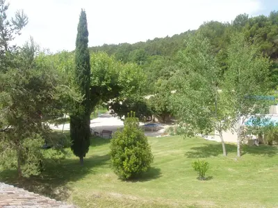 a view of a yard with trees and a pool at B&B Les Argiles in Mérindol