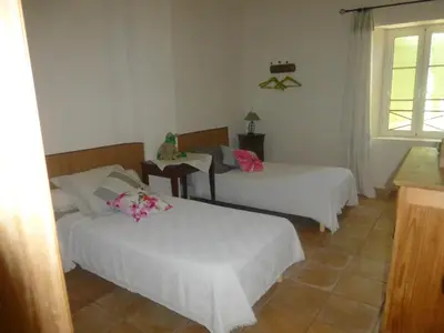 a bedroom with two beds and a table and a window at B&B Les Argiles in Mérindol