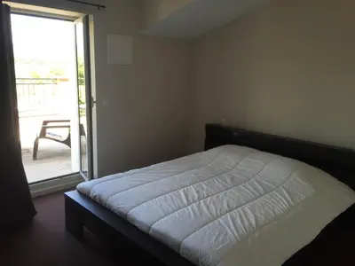 a bedroom with a bed and a sliding glass door at Auberge Les Olivades in Mallemort