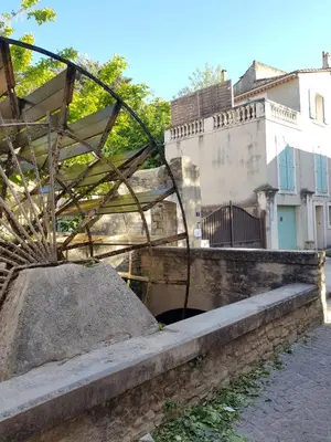 a wooden bench sitting on top of a bridge at La Magnanerie de l'Isle B&B in LʼIsle-sur-la-Sorgue