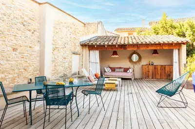 a patio with a table and chairs on a deck at La Magnanerie de l'Isle B&B in LʼIsle-sur-la-Sorgue