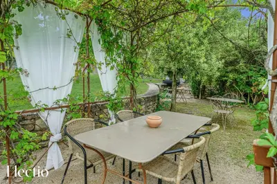 a table and chairs in a garden with trees at Résidence Les Petitons in Oppède