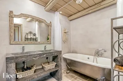 a bathroom with a tub and a large mirror at Résidence Les Petitons in Oppède
