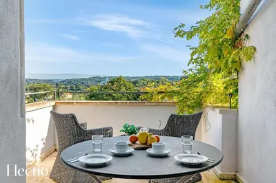 a table with a bowl of fruit on a balcony at Résidence Les Petitons in Oppède
