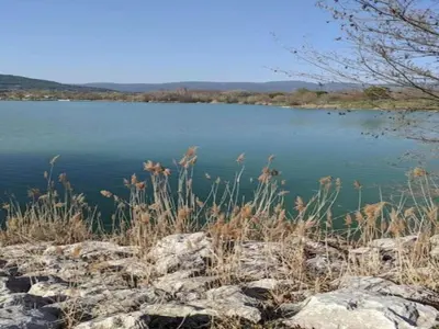a view of a lake with some grass and rocks at Villa in Lubéron with Saltwater Pool in Apt