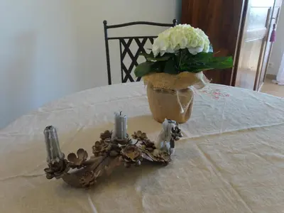 a vase with flowers and candles on a table at Le Mazet du Domaine in Gordes