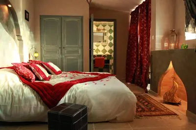 a bedroom with a large bed with red pillows at Gîtes maisons de vacances Domaine la Chamade Carpentras in Carpentras