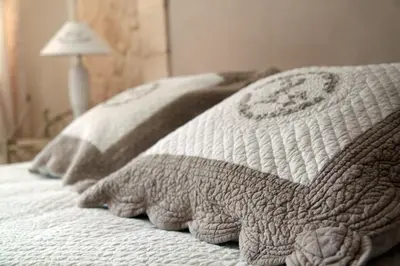a bed with three pillows on it with at Gîtes maisons de vacances Domaine la Chamade Carpentras in Carpentras