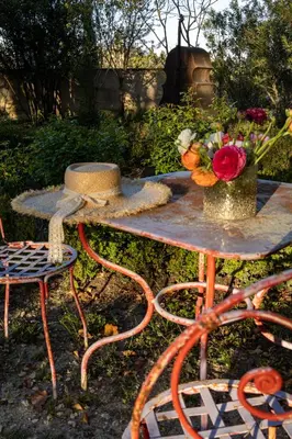 a table and chairs with a vase of flowers on it at Le Clos de Lucie in Lagnes