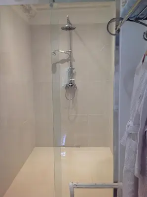 a shower with a glass door in a bathroom at Le Clos de Lucie in Lagnes