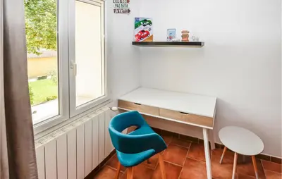a small room with a desk and a blue chair at Awesome Home In Chateuneuf De Gadagne in Châteauneuf-de-Gadagne