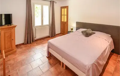 a bedroom with a bed and a television in it at Awesome Home In Chateuneuf De Gadagne in Châteauneuf-de-Gadagne